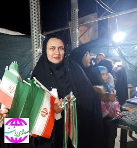 اقدام انسانی  بانوی باشتی میان تجمعات مردمی؛ توزیع  پرچم و پذیرایی با روحیه‌ای خیرخواهانه
